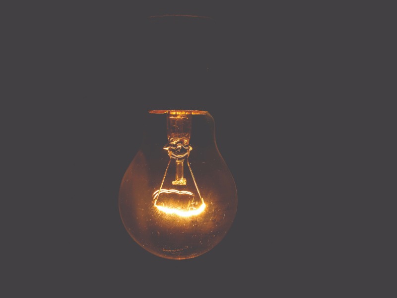 A light bulb hanging in a dark room