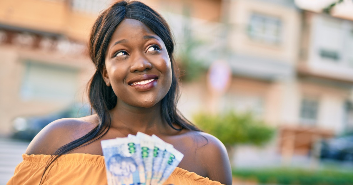 Women hundred rand notes and looking up to the side