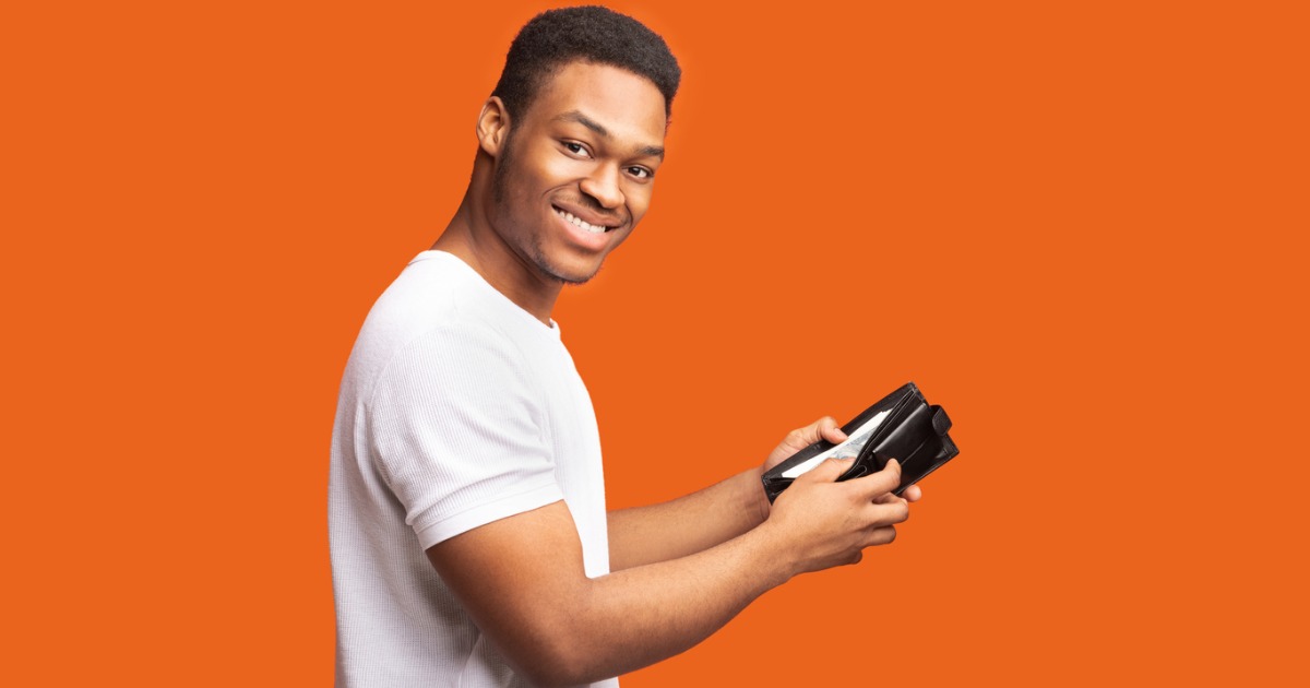 Smiling black man looking towards the camera with a wallet in his hand