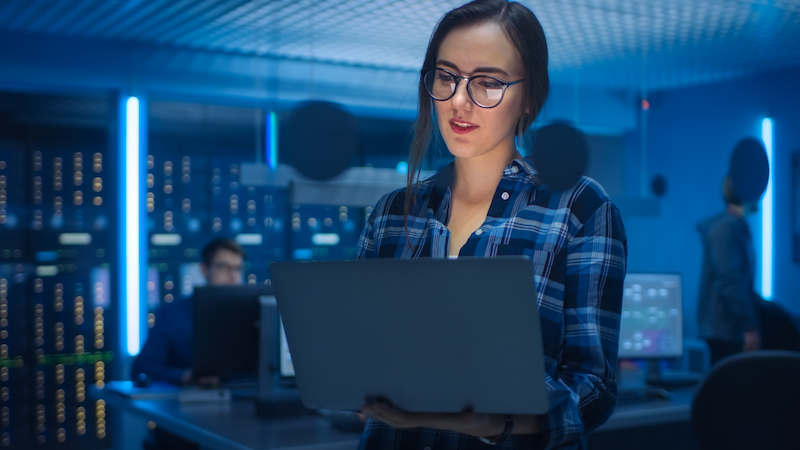 Woman in a laptop in a server room