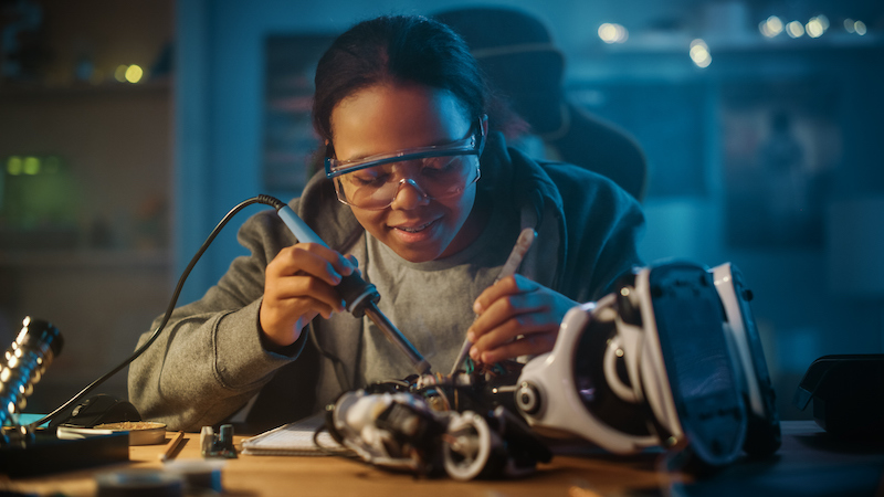 Women soldering a piece of equipment