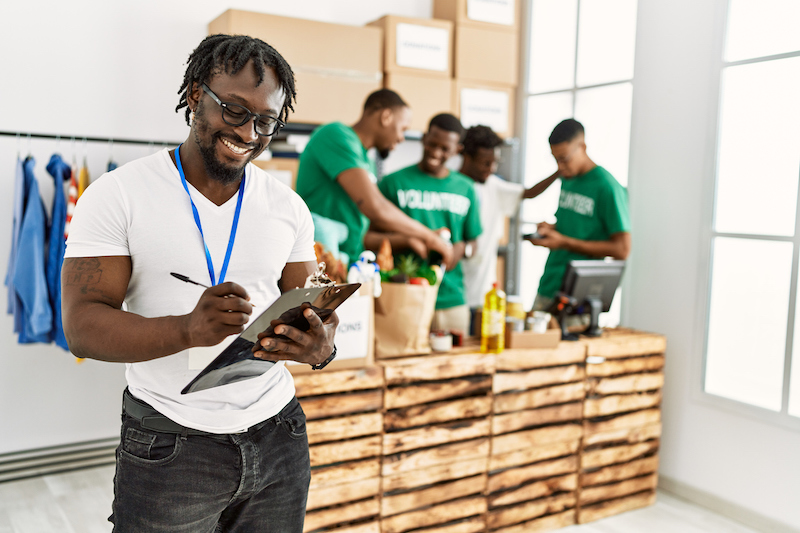 Man with a clipboard with volunteers behind him