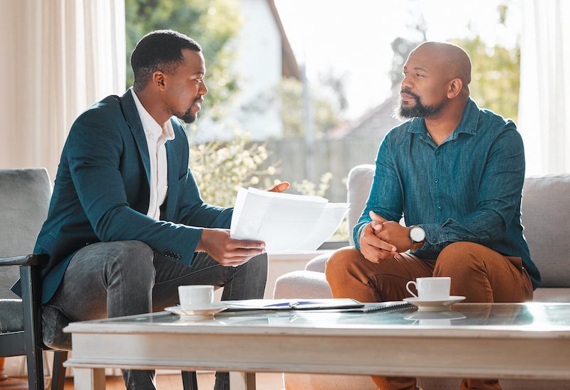 Two black men sitting down in discussion