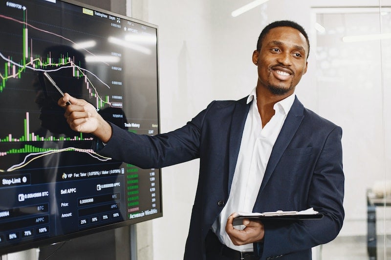 Black man pointing to a screen with sales data