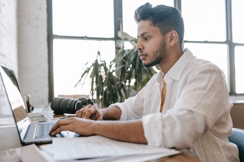 A young man at a desk working on a computer